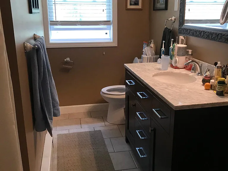 Upstairs bathroom with newer vanity, toilet, mirror and lighting. Ceramic tile floor.