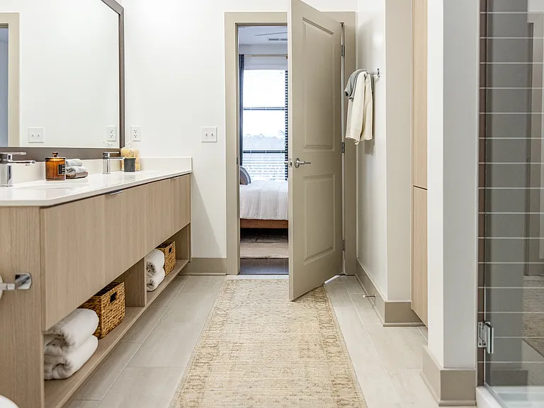Spacious and serene bathroom featuring sleek finishes and ample storage.