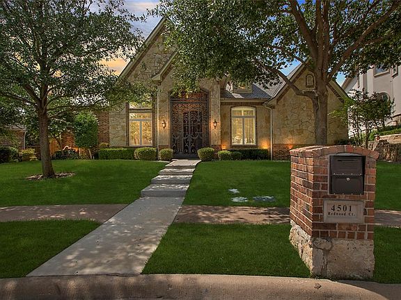 View of front of property featuring stone siding and a lawn