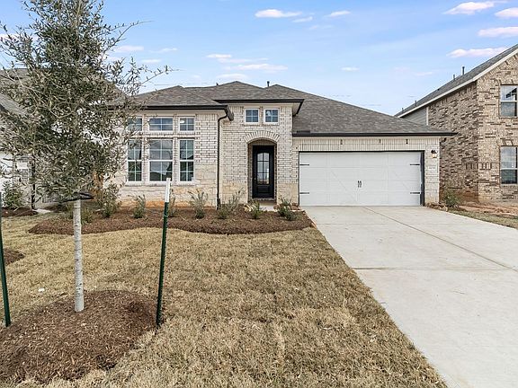 This stunning home has lovely curb appeal, a well-manicured lawn, beautiful landscaping, stone and b