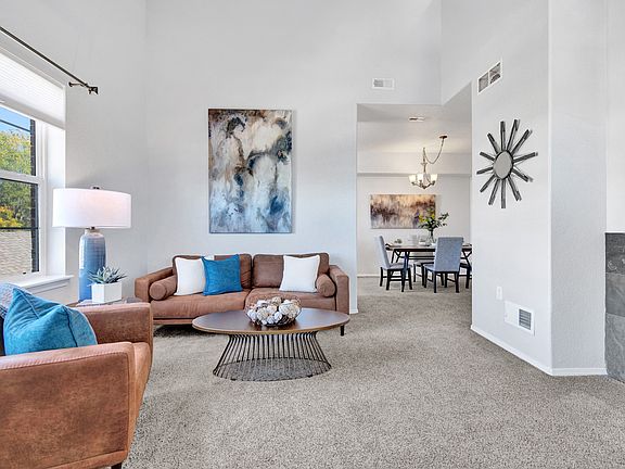 Staged living room space with view into dining room