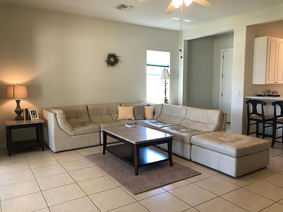 Front door opens into living room. Sliding doors to back lanai on the left. Kitchen on the right.