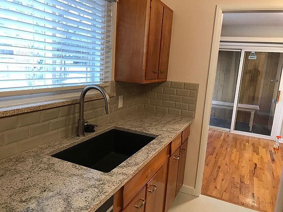 Kitchen with quartz countertops, full tile backsplash, quartz composite sink, LVP flooring.