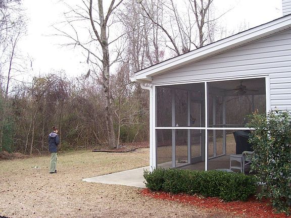 exterior pic of rear w/ woods and porch