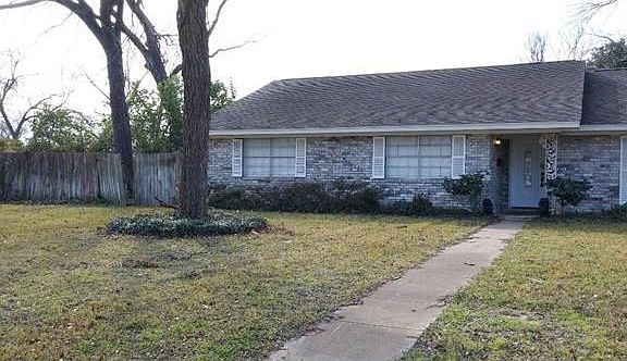 Front of home showing large front yard and fenced backyard.