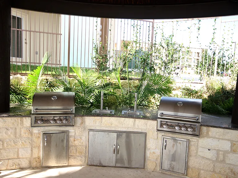 Outdoor BBQ pits next to the pool area