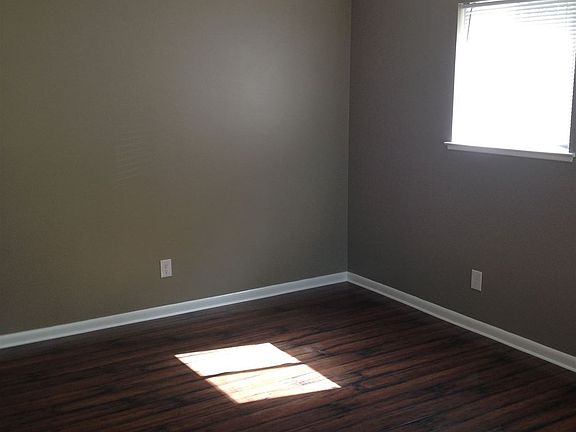 Freshly painted living room with dark plank flooring and lar