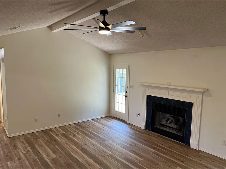 living room with fireplace and door to backyard