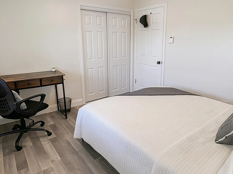 A1 Blue: Large, sunlit room with full memory foam bed, desk, smart lock, and ceiling fan work and rest in comfort.