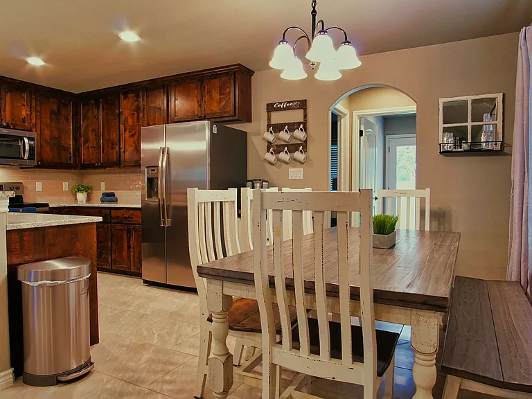 The kitchen offers stainless steel appliances, a breakfast bar with seating for 3, and a refrigerator that stays with the home.