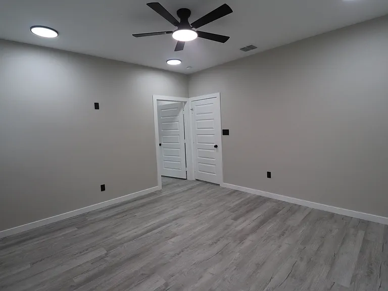 Spacious primary bedroom featuring modern flooring, recessed lighting, a ceiling fan, and a comfortable open layout.