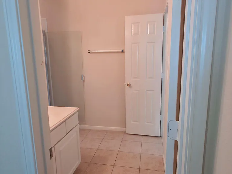 Clean tiled bathroom with a vanity, towel bar, and tub/shower areaan easy-to-maintain space for daily routines.