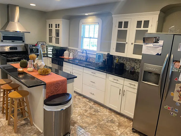Huge eat-in kitchen with barstools. Granite countertops.