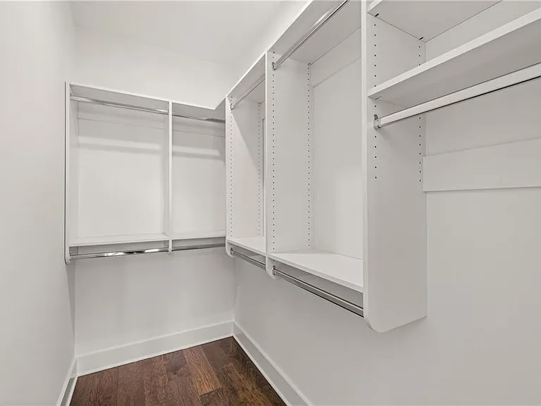 Guest Bedroom Closet (Note: Actual unit has light wooden floors and upgraded fixtures / appliances)