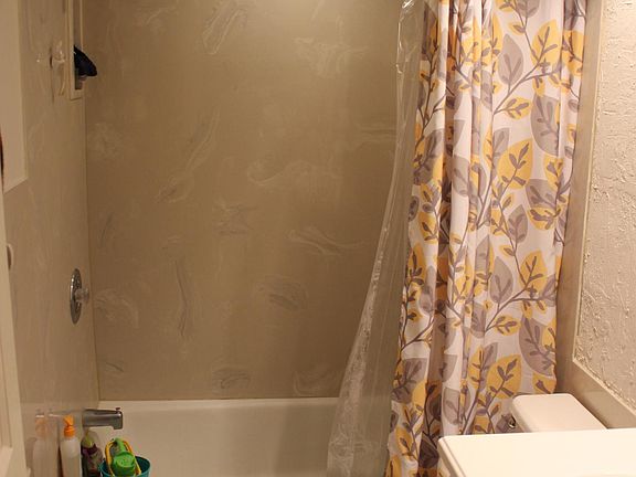 Bathroom with shower curtain open , linen closet located outside of bathroom