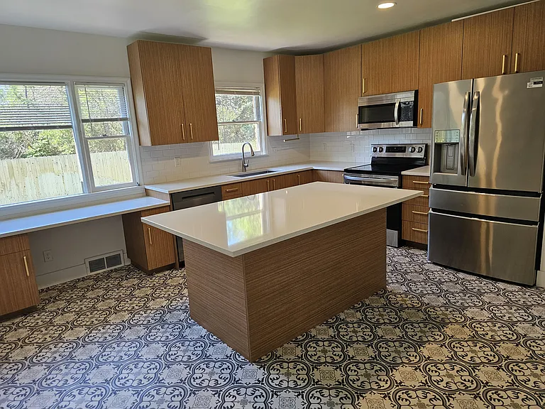 Updated kitchen with ample cabinet and counter space looks out to backyard.
