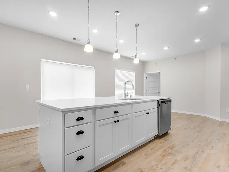 Modern kitchen with a sleek island, bright pendant lighting, and elegant hardwood floors. Modern kitchen with a sleek island, bright pendant lighting, and elegant hardwood floors.