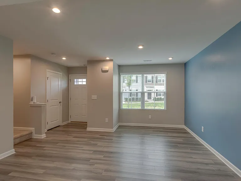 Living room with half bathroom and coat closet located in front entryway