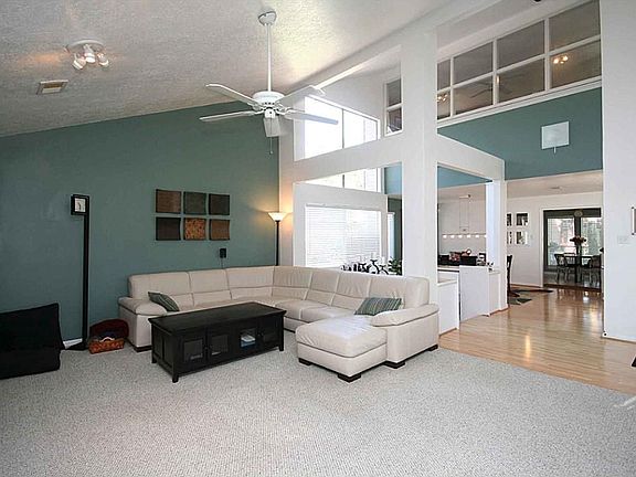The sloped ceiling and stacked windows in the adjoining room bring light and airiness to the family room.