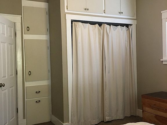 Bedroom closet has built in cupboards for plenty of linen storage.