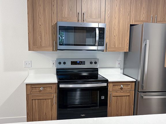 Modern stainless steel appliances paired with warm cabinetry create a kitchen you'll love coming home to.