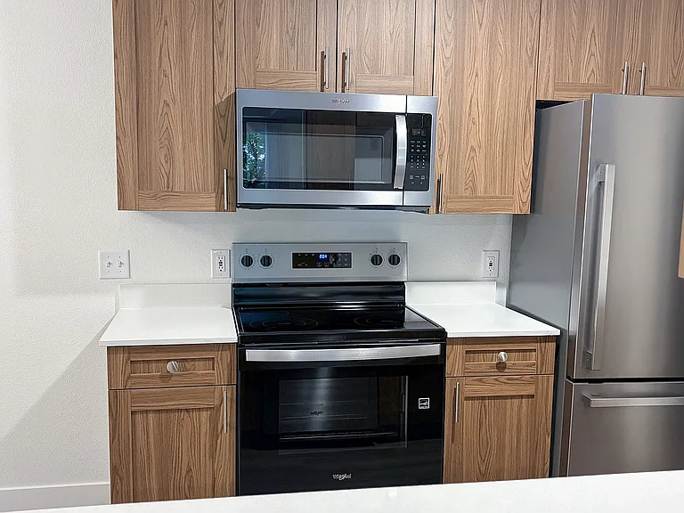 Modern stainless steel appliances paired with warm cabinetry create a kitchen you'll love coming home to.