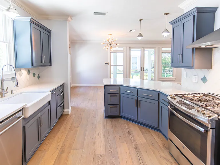 Farmhouse sink and stainless steel appliances complement the quartz countertops.