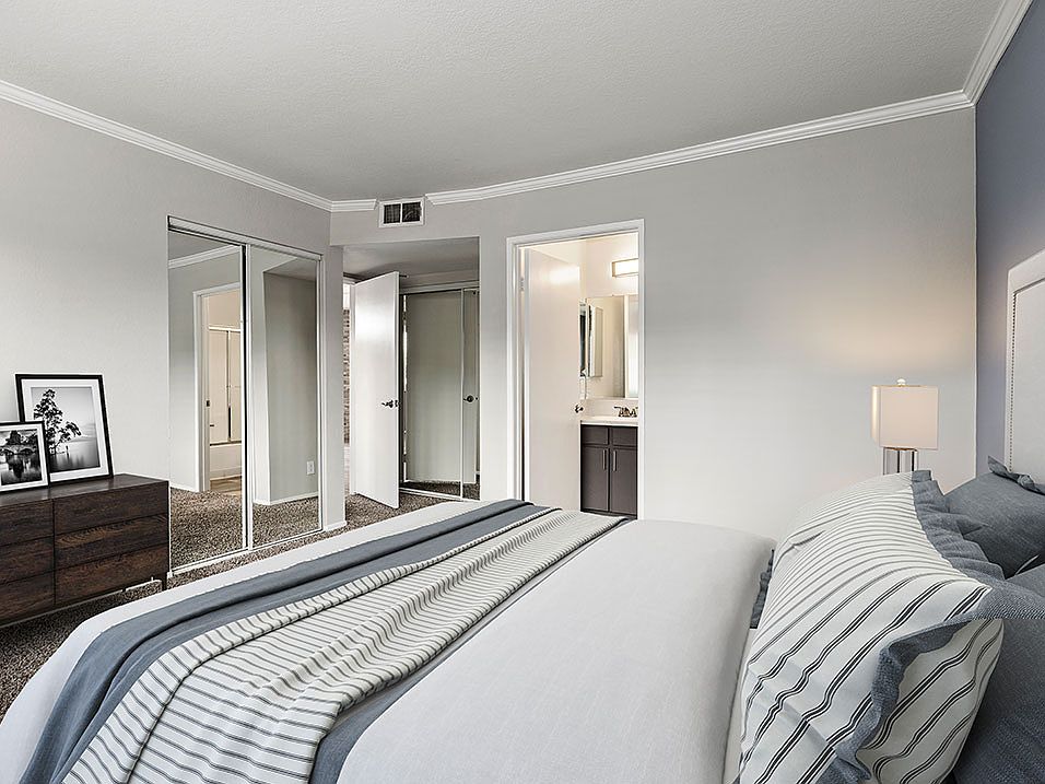 Carpeted bedroom with access to private bathroom.