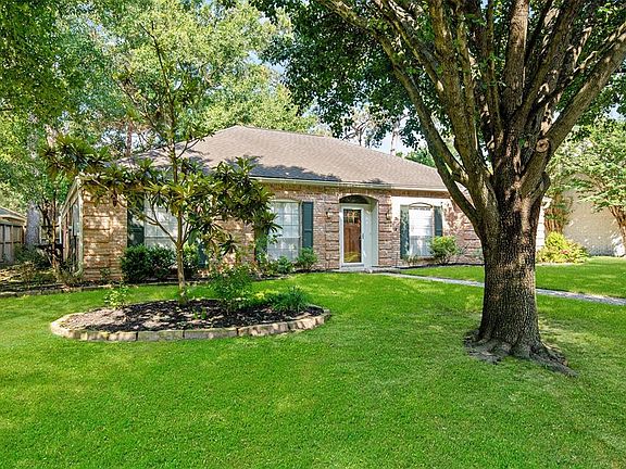 A pebble stone walkway leading to a mahogany and storm door is sure to greet your guests in style!