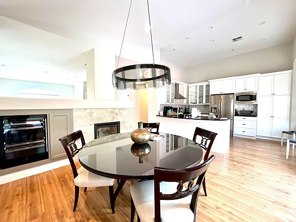 Open Concept - gorgeous dining room with fireplace and wine refrigerator - open to kitchen and outdoor patio