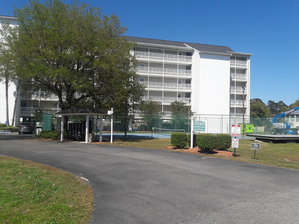 Front of building with tennis court and mailboxes