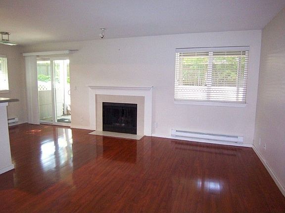 Spacious open living room w/fireplace & dining room; beautiful premium cherry wood pergo for continu