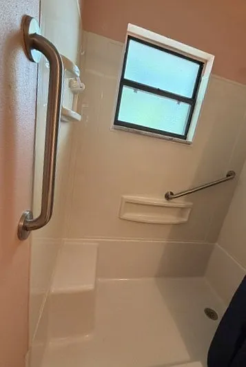 Walk-in shower in hall bathroom. Grab bars for safe entry and exit for people of all ages.
