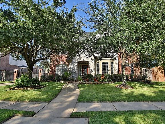 This home is in the Woods section of Gleannloch Farms and offers sidewalks and brick fences.