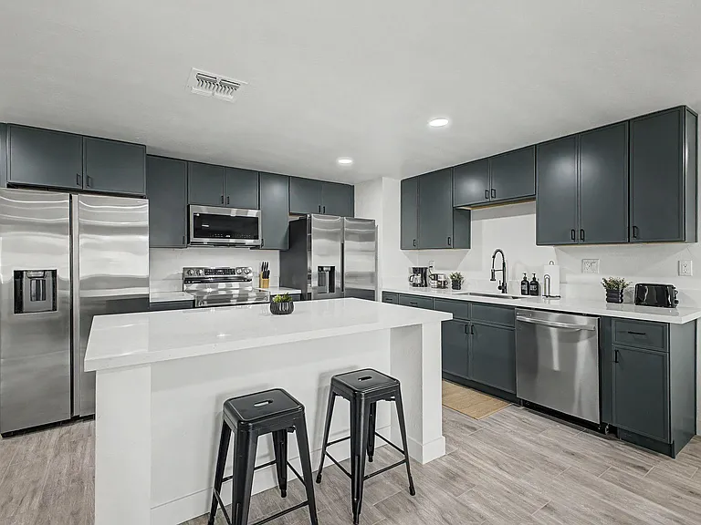 Spacious kitchen with a large breakfast island, ample cabinetry, and stainless steel appliances for easy meal prep.