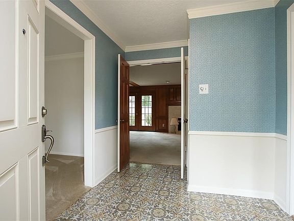 Light and bright entry w/double doors into den and formal living room & dining room on either side with bay windows.