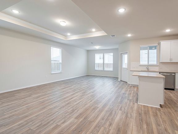 Open-concept living area with recessed lighting and large windows