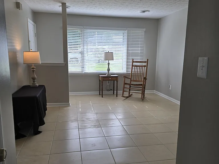 View of front entrance/window; bomb proof cream tile flooring in living room, hallway, and bathroom; neutral, warm wall color (newly painted "Agreeable Gray").