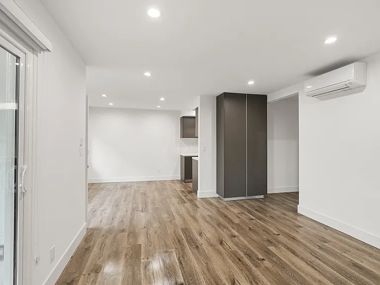 Living Room Area with Vinyl Flooring, Wall Heater, and Patio Entrance