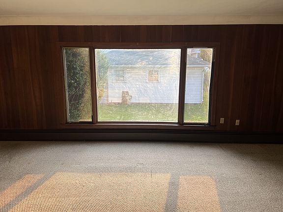 Living Room view of fenced in back yard and two car garage.