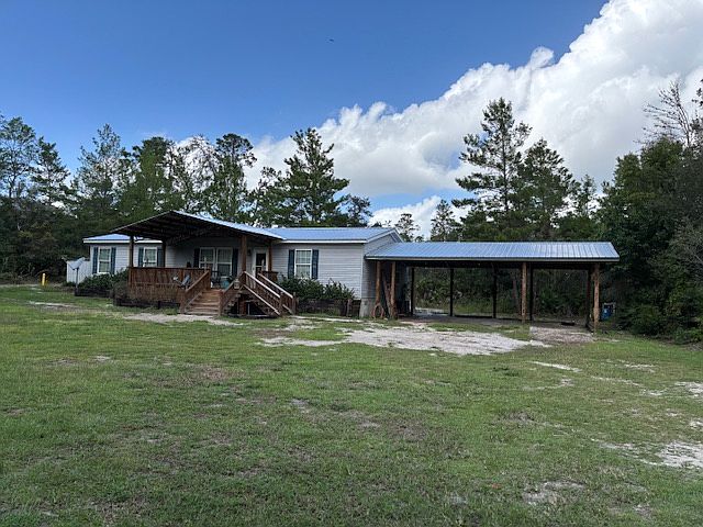 Enjoy the beautiful forest on this large front porch. Three car carport provides cover for automobiles and recreational vehicles,