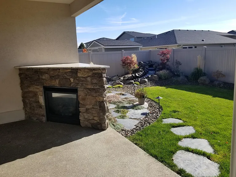 Covered patio w/gas fireplace and view of waterfall.