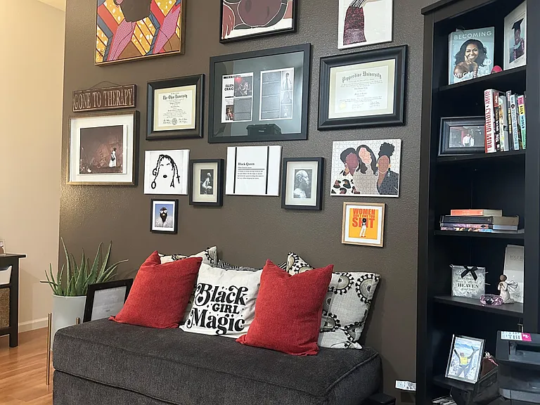 Inviting common lounge with a comfortable sofa, wood-look flooring, and a large display wall ideal for relaxing.