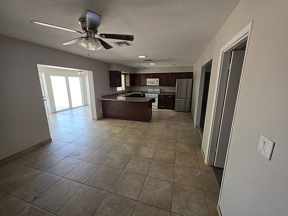 Kitchen and dining area. Sun room is seen where the large glass windows are.