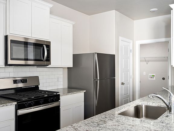 The kitchen of the Coastal has beautiful white cabinets.