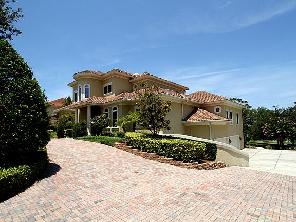 Oversized four car garage with large parking pad & circular drive