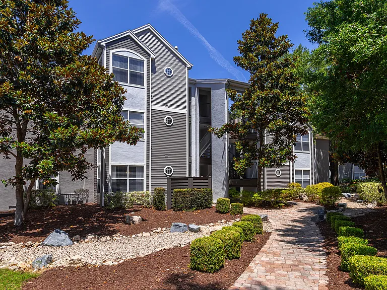 Follow the winding walkway to your apartment home past vibrant greenery and freshly painted buildings.