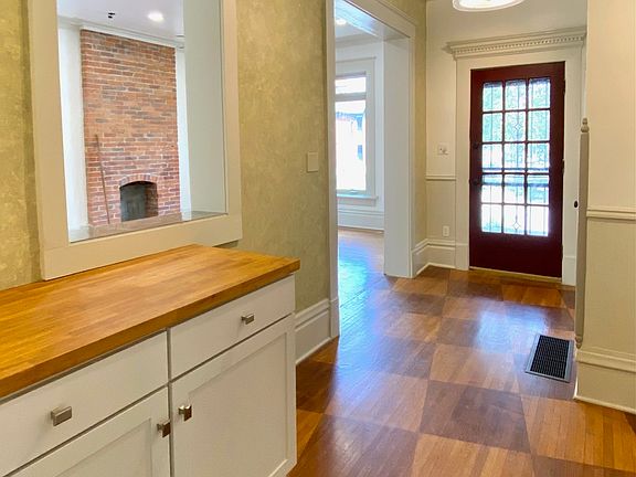 Entry foyer with custom stained hardwood floors and pass-through window to living room