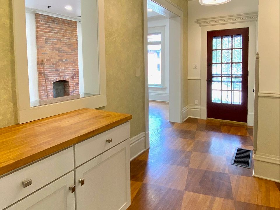 Entry foyer with custom stained hardwood floors and pass-through window to living room