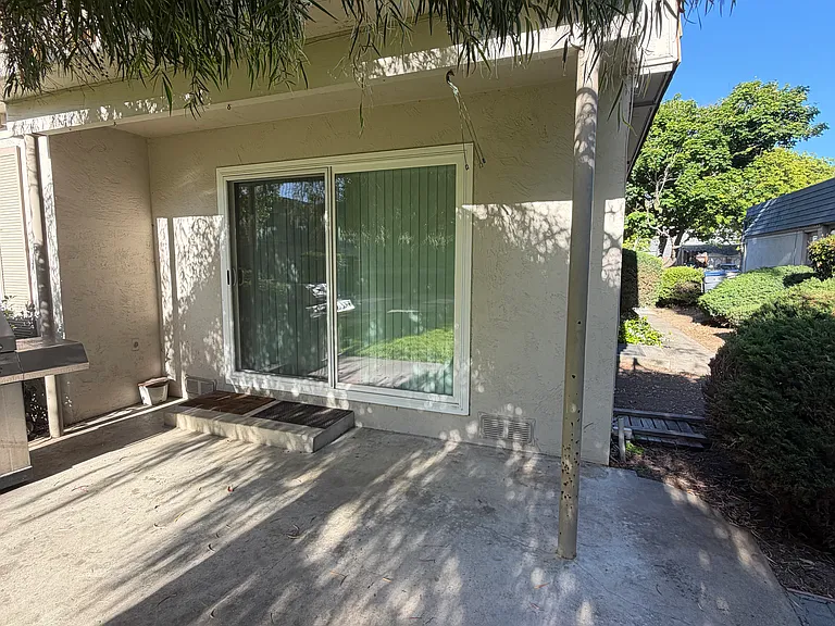 Patio space that opens toward landscaped community grounds.